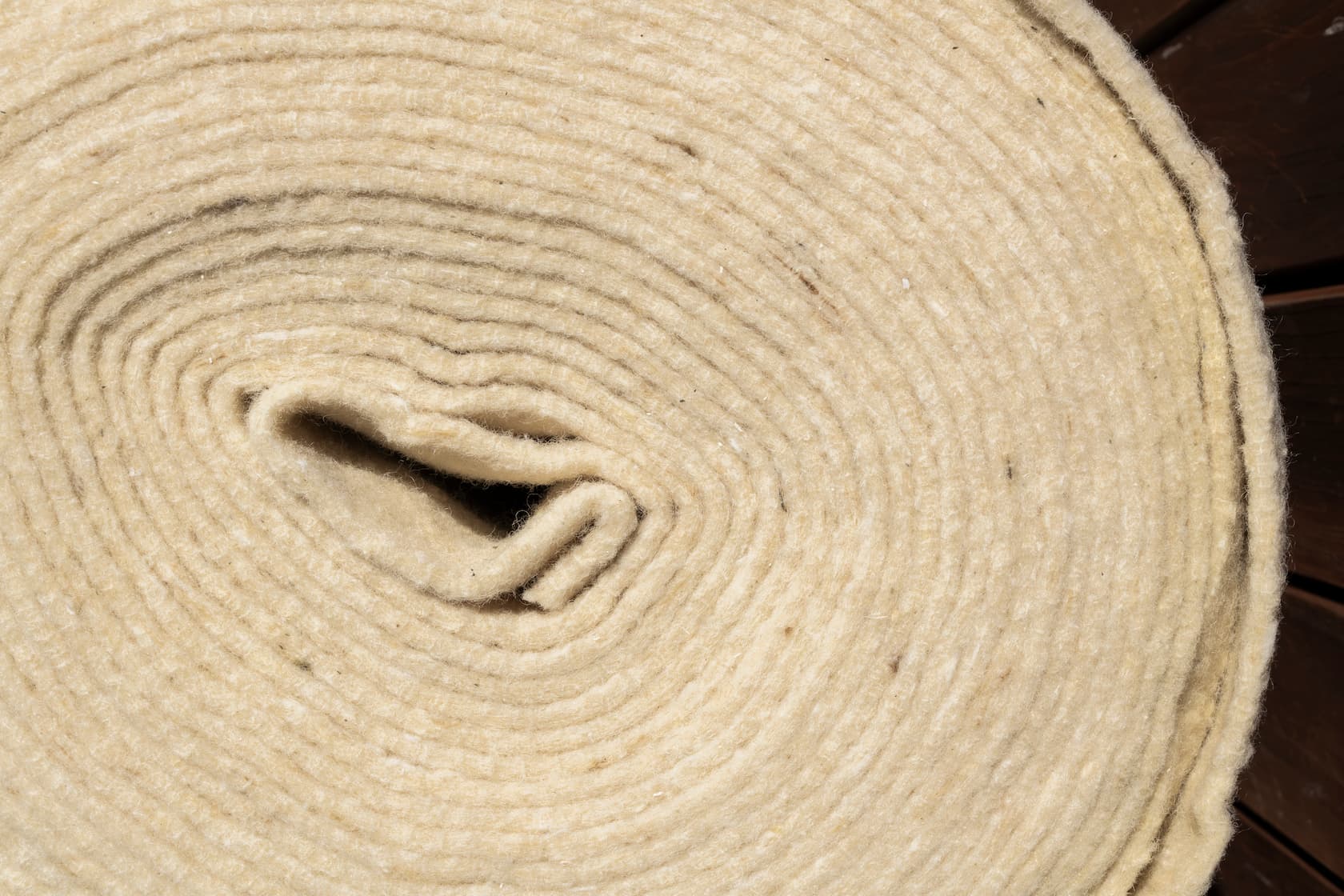 Wool mulch mat rolls laid in garden for weed control and moisture retention