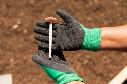 White biodegradable garden peg securing wool mulch mats sustainably